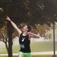 A participant running while pointing and looking up at the sky